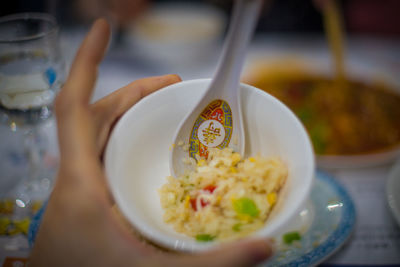 Close-up of hand holding soup in bowl