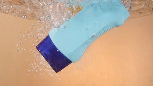 Close-up of bottle falling in water