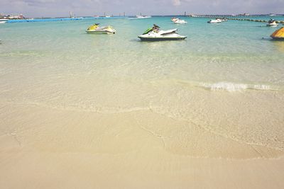 Boats moored on beach against sky