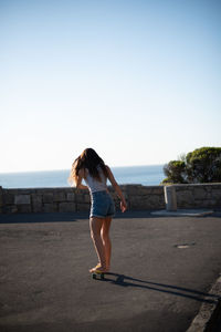 Rear view of woman standing against clear sky