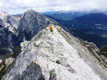 Hiker on rocky mountain against sky