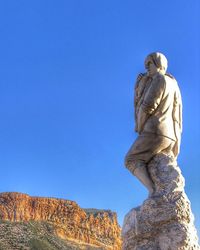 Low angle view of statue against clear blue sky