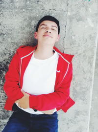 Portrait of young man standing against wall