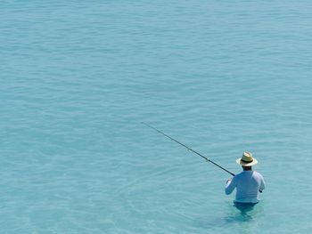 Rear view of man fishing in sea