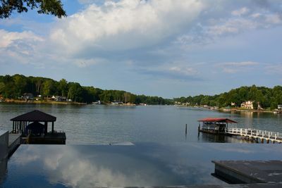 Scenic view of infinity pool and lake against sky