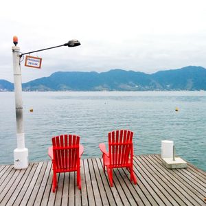 Empty chairs overlooking calm lake