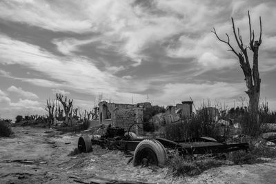 Old abandoned building on field against sky