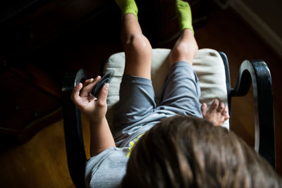 Child playing with fidget spinner while sitting on chair in darkroom