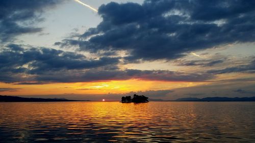 Silhouette boat in sea against sky during sunset