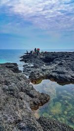 Scenic view of rocks in sea against sky