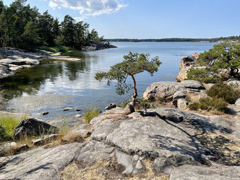 Scenic view of rocks by lake against sky