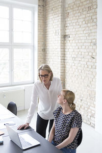 Mature businesswoman working with younger colleague in office