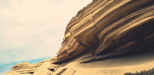 Low angle view of rock formation against sky