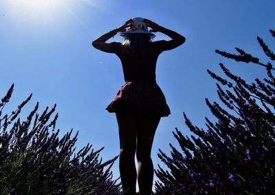 Low angle view of woman standing against the sky