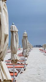 Rear view of umbrellas on beach against clear sky