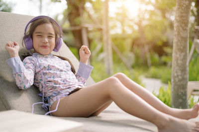 Full length of cute girl sitting outdoors