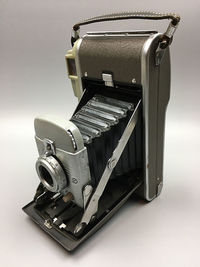 Close-up of vintage camera against gray background
