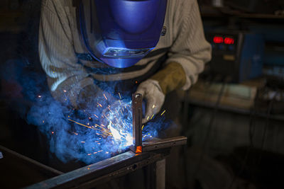 Midsection of welder working in workshop