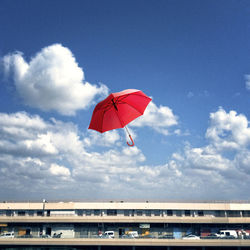 Red umbrella against sky