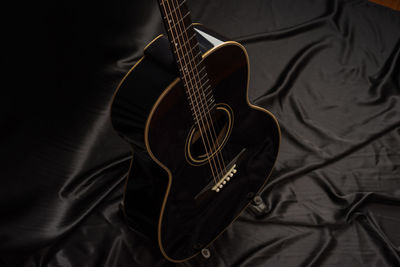 High angle view of guitar on bed