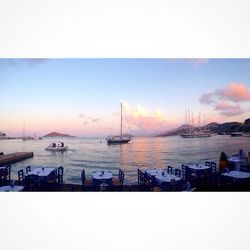 Boats in sea at sunset