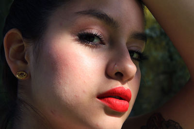 Close-up portrait of confident beautiful woman with red lipstick