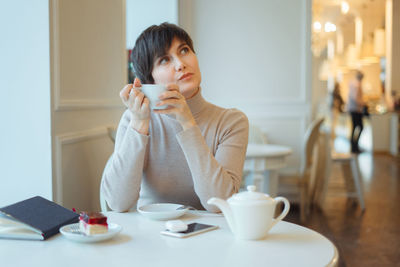 Thoughtful woman sitting in cafe