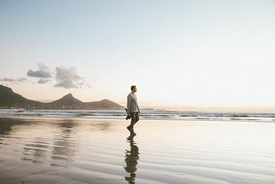 Rear view of woman standing on beach