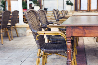 Empty chairs and tables in cafe against building