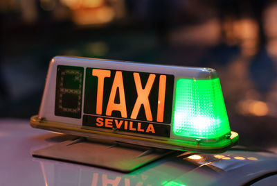 Close-up of illuminated sign on taxi at night