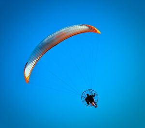 Low angle view of parachute against blue sky