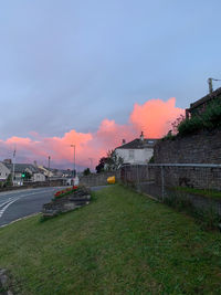 Cars on road against sky during sunset