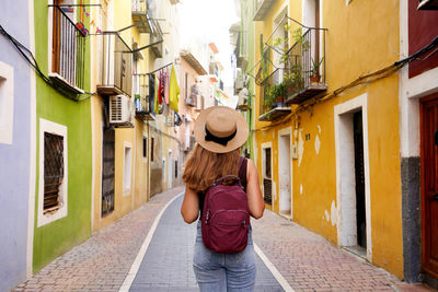 Happy tourist girl visiting the colorful spanish village villajoyosa, alicante, spain.