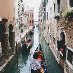 Boats in canal along buildings