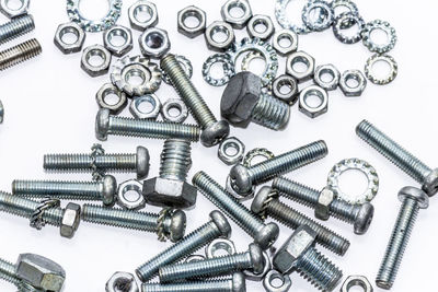 Close-up of screws and nuts over white background