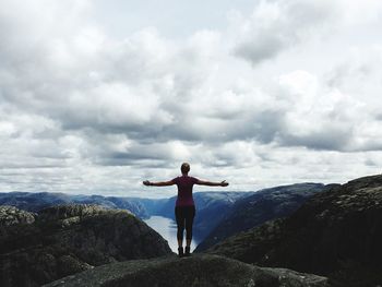 Woman standing on rock against sky