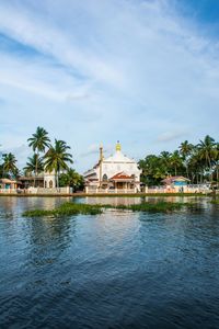 View of church and palm trees against the sky at alleppey backwaters