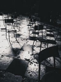 High angle view of empty chairs and table in abandoned building