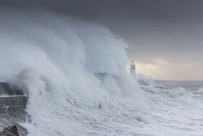 Scenic view of waves splashing against sky