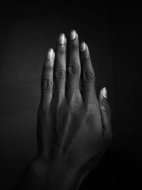 Close-up of human hand against black background