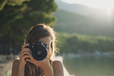 Portrait of woman photographing outdoors