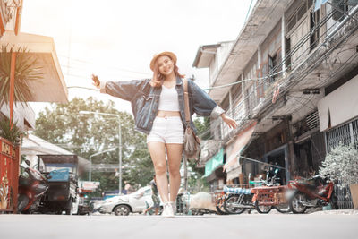 Happy young woman on street in city