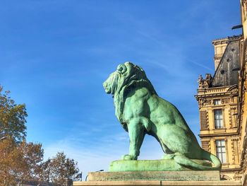 Low angle view of statue against blue sky