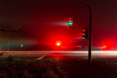 Side view of illuminated traffic lights in foggy night