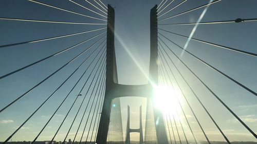 Low angle view of cable-stayed bridge against blue sky on sunny day