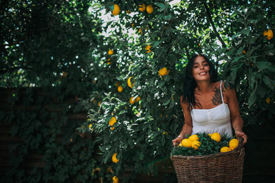 Young woman wearing mask against trees and plants