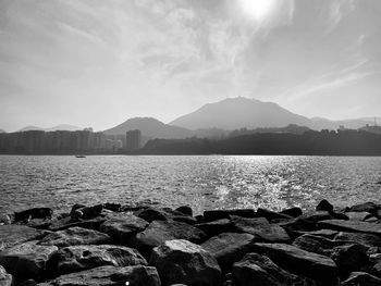 Scenic view of sea by mountains against sky