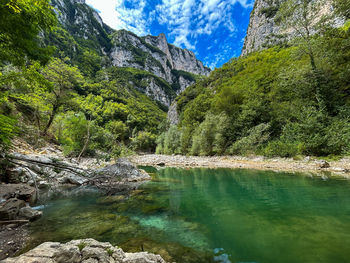 Scenic view of river amidst mountains against sky