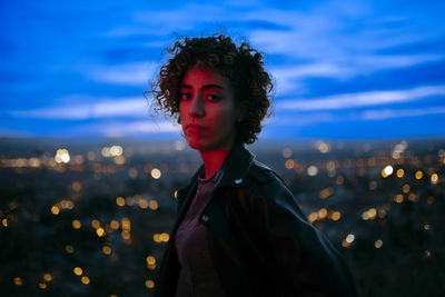 Portrait of young woman looking away against sky