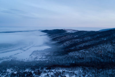 Scenic view of snow covered land against sky